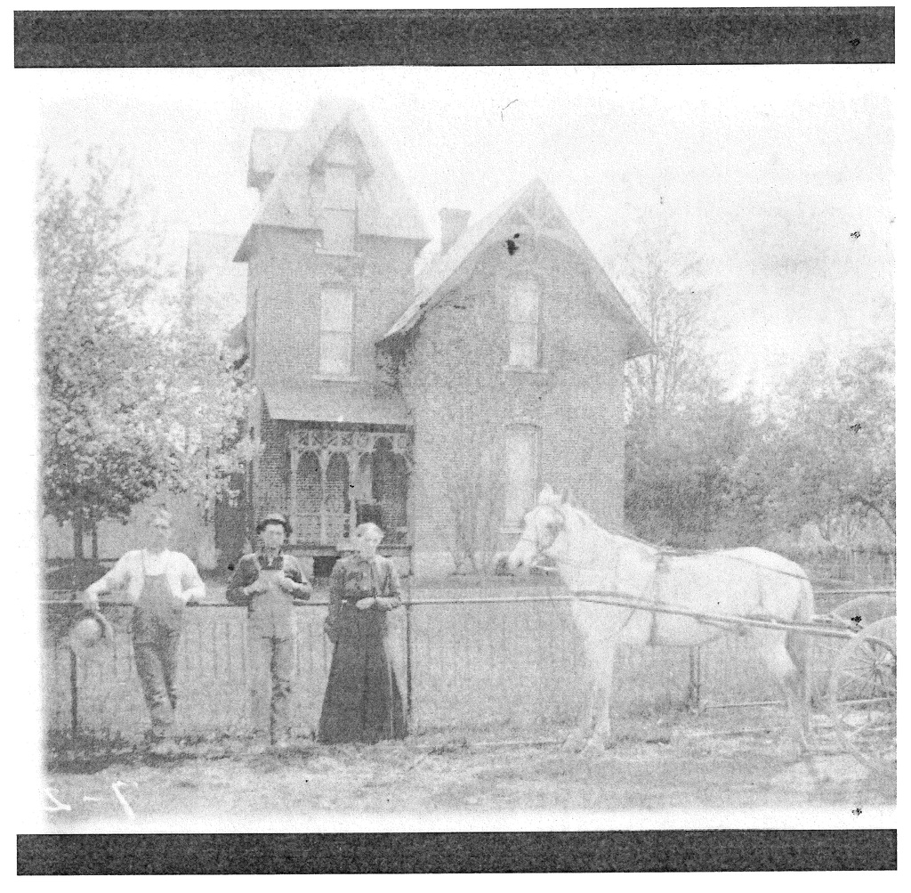 A house, 3 people, and a horse
