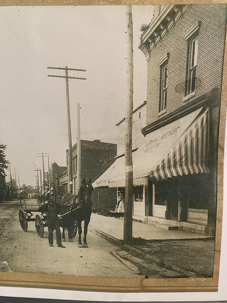 Storefront (John L Becker Bakery) with horse-drawn wagon and man out front