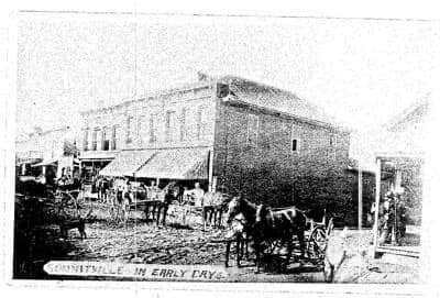 Downtown street corner with horse carriages