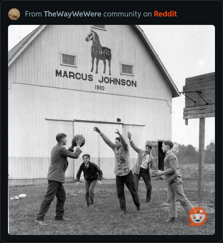 Boys playing basketball in front of a barn